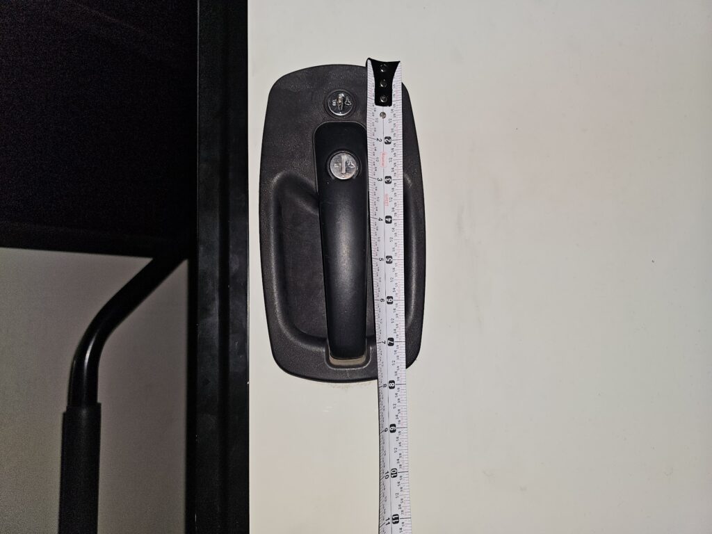 Measuring horizontal width of RV camper door lock for replacement and keying services.