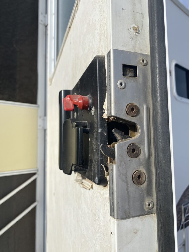 Close-up of RV camper storage compartment lock needing key service.