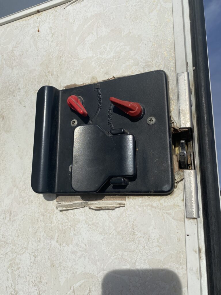 Close-up view of RV camper locking mechanism during door repair.